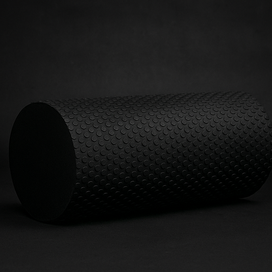 Black high-density foam roller for deep tissue muscle recovery on dark background